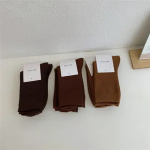 Gros plan détaillé de chaussettes unies côtelées avec étiquette sur une table propre.