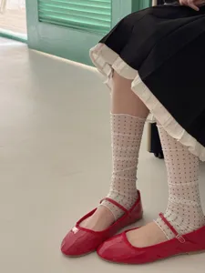 Detailed view of stylish sheer polka dot calf socks and leg warmers, perfect for summer.