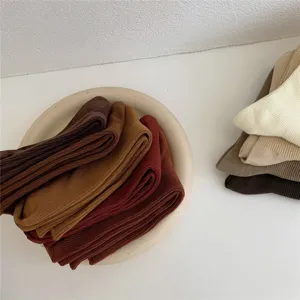 Gros plan détaillé de chaussettes en coton doux soigneusement empilées aux tons d'automne.