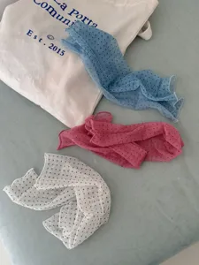 Close-up of sheer polka dot footless socks in blue, pink and white. Summer fashion leg warmers.