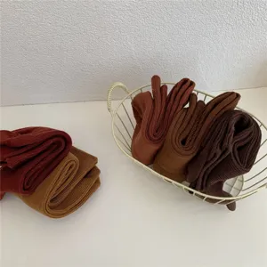 Vue détaillée de chaussettes mi-hautes unies en tricot dans un panier, tissu doux et confortable.
