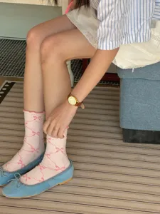 Close-up detail of women's pink casual socks featuring cute bow patterns, breathable spring wear.