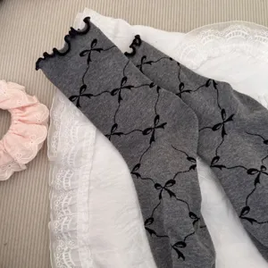 Japanese grey mid tube socks with black bow pattern and sweet rolled edge design style.
