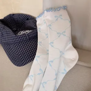Close-up of Japanese style women mid-tube socks featuring blue bow print and rolled ruffles.