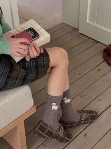 Detail shot of cute woolen knit crew socks with charming dog pattern for cozy autumn and winter.