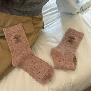 Detail shot of pink speckled wool blend mid-tube socks featuring a cute puppy pattern.