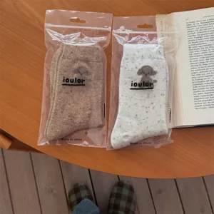 Detailed view of cute puppy pattern wool colorful flecks mid-tube socks in transparent bags.