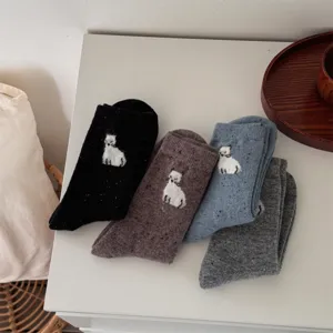 Close-up of soft knit wool blend socks featuring cute animal patterns and colorful speckles.