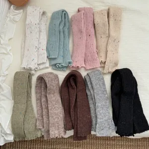 Scaldascamini in maglia spessa con punti colorati e bordi volant per l'inverno accogliente.