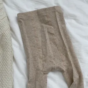 Detailed shot of textured oatmeal knit winter tights with colorful flecks for women.