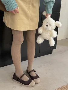 Detailed shot of solid color cotton pantyhose worn with vintage outfit for autumn and winter.