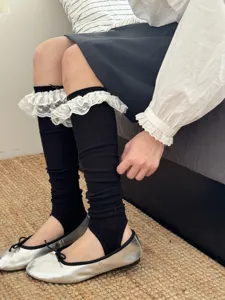 Womens black stirrup leg warmers with sweet white lace ruffle trim detail fashion socks.