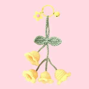 Handmade crochet lily of the valley keychain detail, cute yellow flower charm and bell.