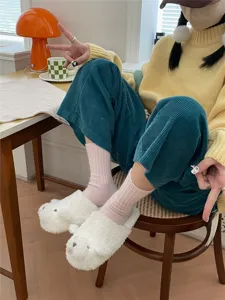 Cozy winter socks and cute fluffy slippers lifestyle detail shot showing soft daily wear comfort.