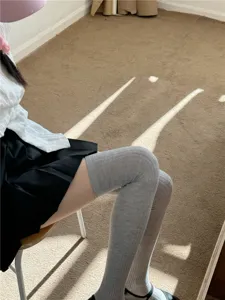 Chaussettes hautes grises pour femmes, bas longs fins et respirants pour look décontracté.