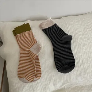 Striped mid-calf socks for women with contrast ribbed cuffs, cozy knit wear for autumn and winter.