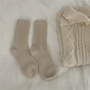 Cozy beige ribbed knit women socks detail shot, soft warm winter hosiery for daily casual wear.