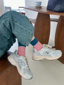 Stylish contrast color striped mid-calf socks for women, cozy casual autumn winter wear detail.