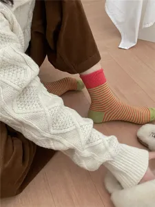 Detail shot of women's contrast striped mid-calf socks with ribbed cuff for autumn winter.