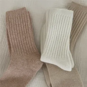 Close-up detail of cozy thick knit winter socks, soft fluffy texture, warm mid-tube design.