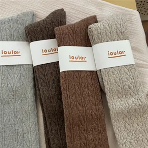 Detailansicht von vier farbigen Strickwoll-Wadensocken mit Struktur und Banderole.