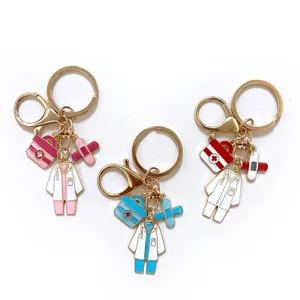 Medical themed metal keychain detail showing miniature doctor coats and first aid kit charms.