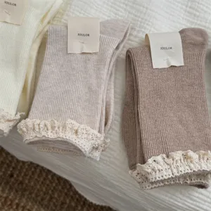 Chaussettes mi-hautes en dentelle douce pour femme, tricot respirant avec poignets à volants délicats.