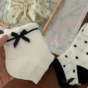 Calzini corti bianchi con fiocco nero, comodo materiale in cotone per donne, vista dettaglio.