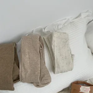 Cozy winter speckled tights detail, soft cotton blend knit fabric in neutral tones for women.