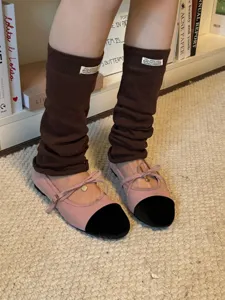 Brown knit leg warmers styled with stylish mary jane shoes for a chic y2k outfit look.