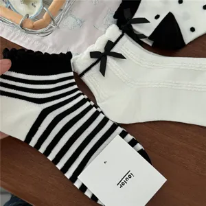 Dettagli di calzini corti da donna in stile dolce con fiocchi carini e righe, morbidi.