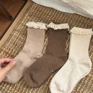 Détail de chaussettes mi-mollet à volants de dentelle douce et texture côtelée élégante.