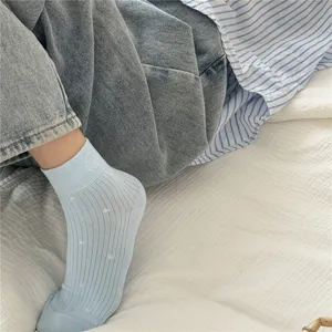 Detail shot of light blue ribbed short socks with cute polka dots, soft and breathable fabric.