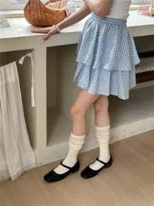 Detailed shot of Japanese style slouchy white socks paired with cute shoes and plaid skirt.