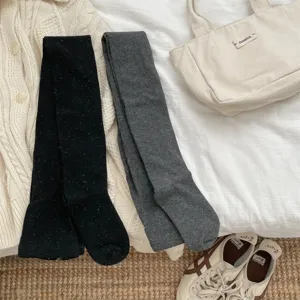 Detailed view of winter speckled tights in black and dark grey, cozy knit aesthetic.