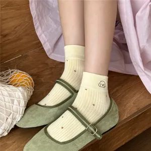 Close-up detail of cute ribbed short socks with tiny dots and lovely puppy embroidery.