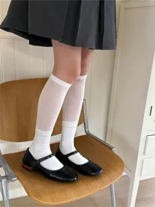 Detail shot of white Japanese style knit over-the-knee socks showing mesh and ribbed texture.