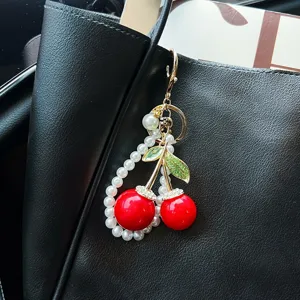 Dettaglio del ciondolo per borsa a ciliegia di perle con metallo squisito e foglie di cristallo.