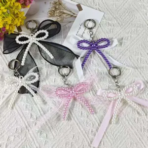 Detailed view of sweet DIY imitation pearl bow keychains with lace and ribbon, cute bag charms.