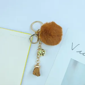 Detailaufnahme des braunen Plüsch-Schlüsselanhängers mit flauschigem Pompon und Glöckchen.