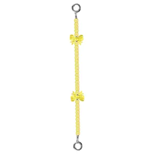 Primo piano dettagliato della catena per cellulare con perline gialle, fiocchi e anelli.