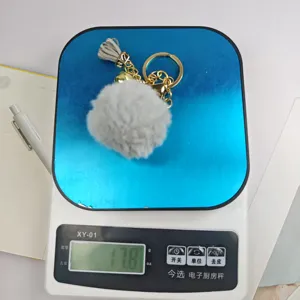 Detailansicht des flauschigen grauen Pompon-Schlüsselanhängers mit Quaste, Ring und Glocke im Test.