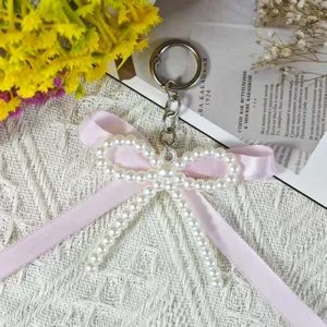 Exquisite handmade pearl bow keychain detail, pink ribbon charm with metal ring for bags or keys.