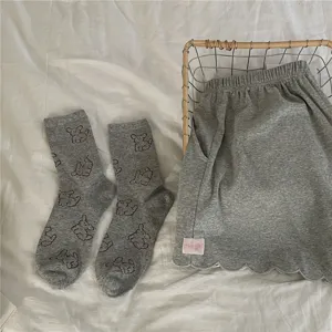 Grey cute dog pattern mid-tube socks and scalloped shorts detail shot, cozy casual style wear.
