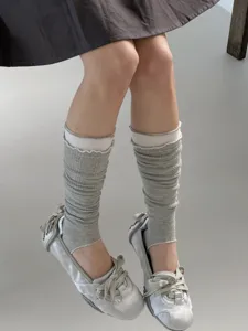 Detailed view of grey stirrup leg warmers with contrast ribbed cuffs, lightweight spring style.