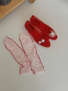 Red jelly flat shoes and pink stirrup leg warmers detail shot showing chic summer outfit.