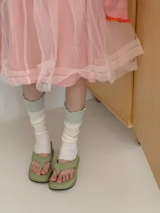 Korean style ruffle leg warmers detail shot, thin knit footless socks worn with sandals.