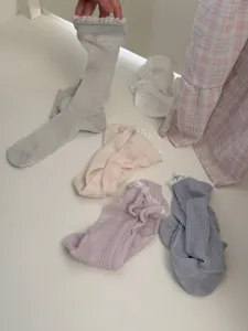 Vue détaillée de chaussettes empilées en dentelle style japonais, tissu léger et respirant.