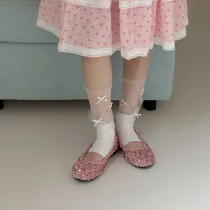 Schattige sokken met strik in mesh gecombineerd met roze pailletten ballerina's.