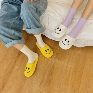 Nahaufnahme von gemütlichen Baumwoll-Socken und niedlichen Smiley-Hausschuhen zu Hause.